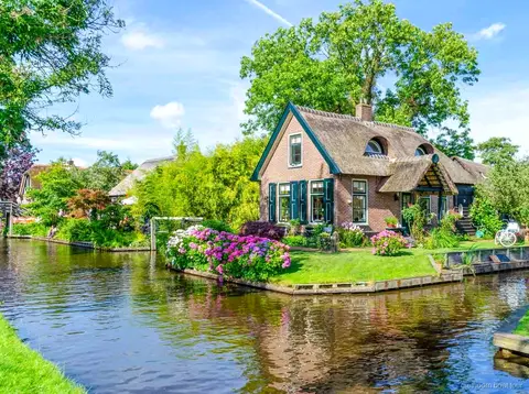 Pareja al timon de su barco de alquiler en un canal de Giethoorn