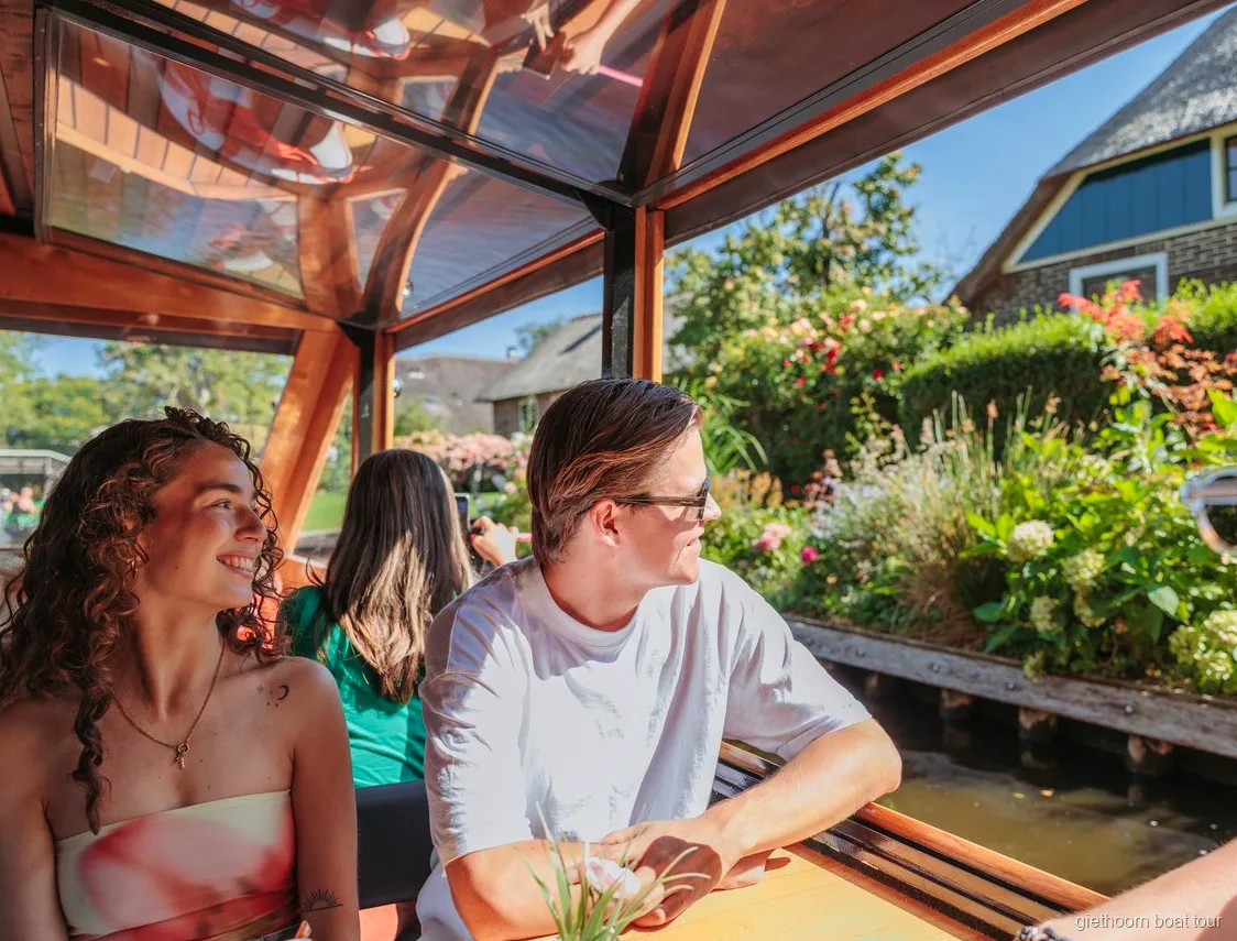 Sazdan çatılı çiftlik evlerinin yanından geçen kanal turu teknesi, Giethoorn