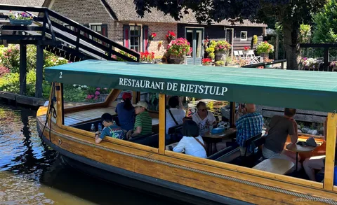 Crucero por los canales de Giethoorn pasando junto a casas con techo de paja cerca del centro del pueblo