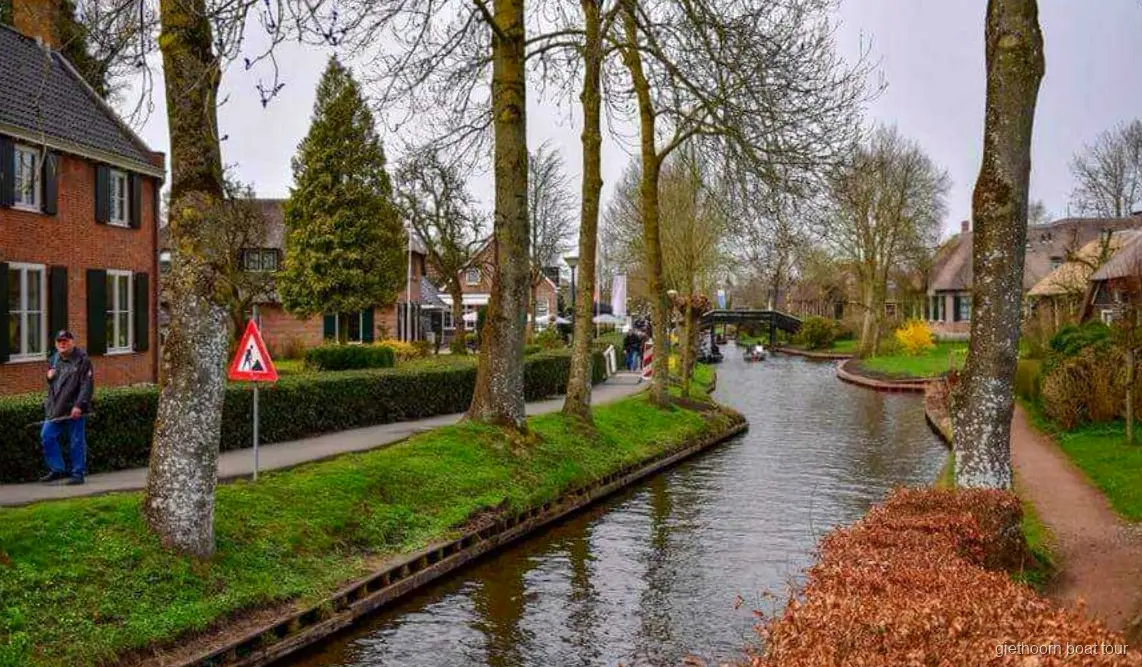 Gids en groep stappen aan boord van de rondvaartboot in Giethoorn