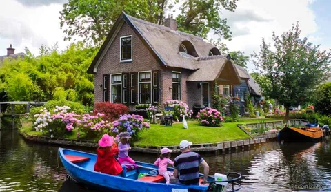Reetgedeckte Bauernhäuser an einer Gracht in Giethoorn beim Tagesausflug