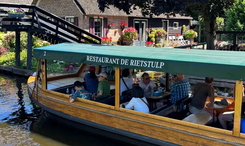 Giethoorn Grachtenfahrt vorbei an reetgedeckten Bauernhäusern nahe dem Dorfzentrum