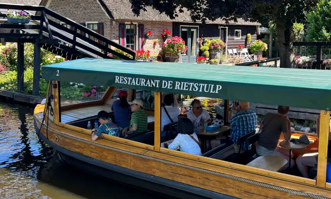 Giethoorn canal cruise passing thatched-roof farmhouses near the village center