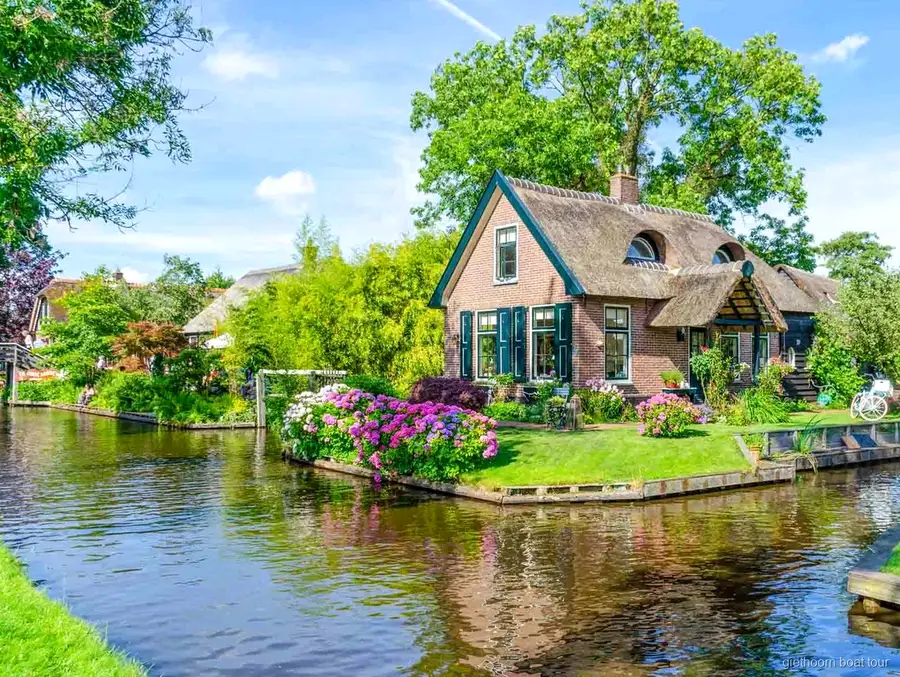 Couple steering their own rental boat through a Giethoorn canal