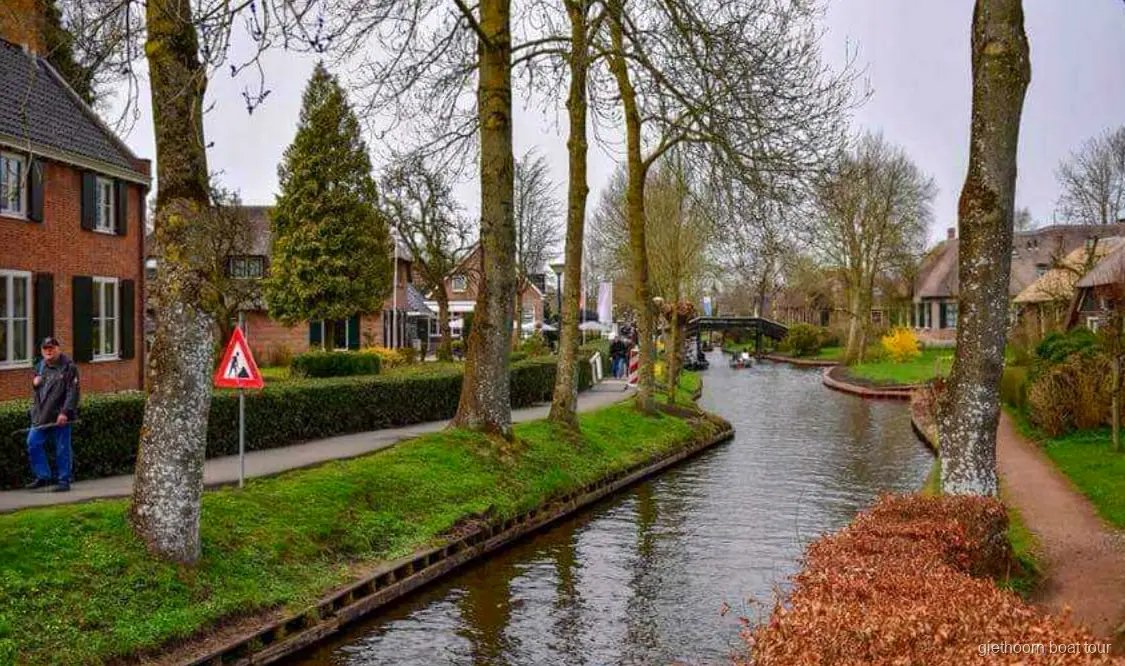 Guida e gruppo che sale sulla barca da crociera a Giethoorn